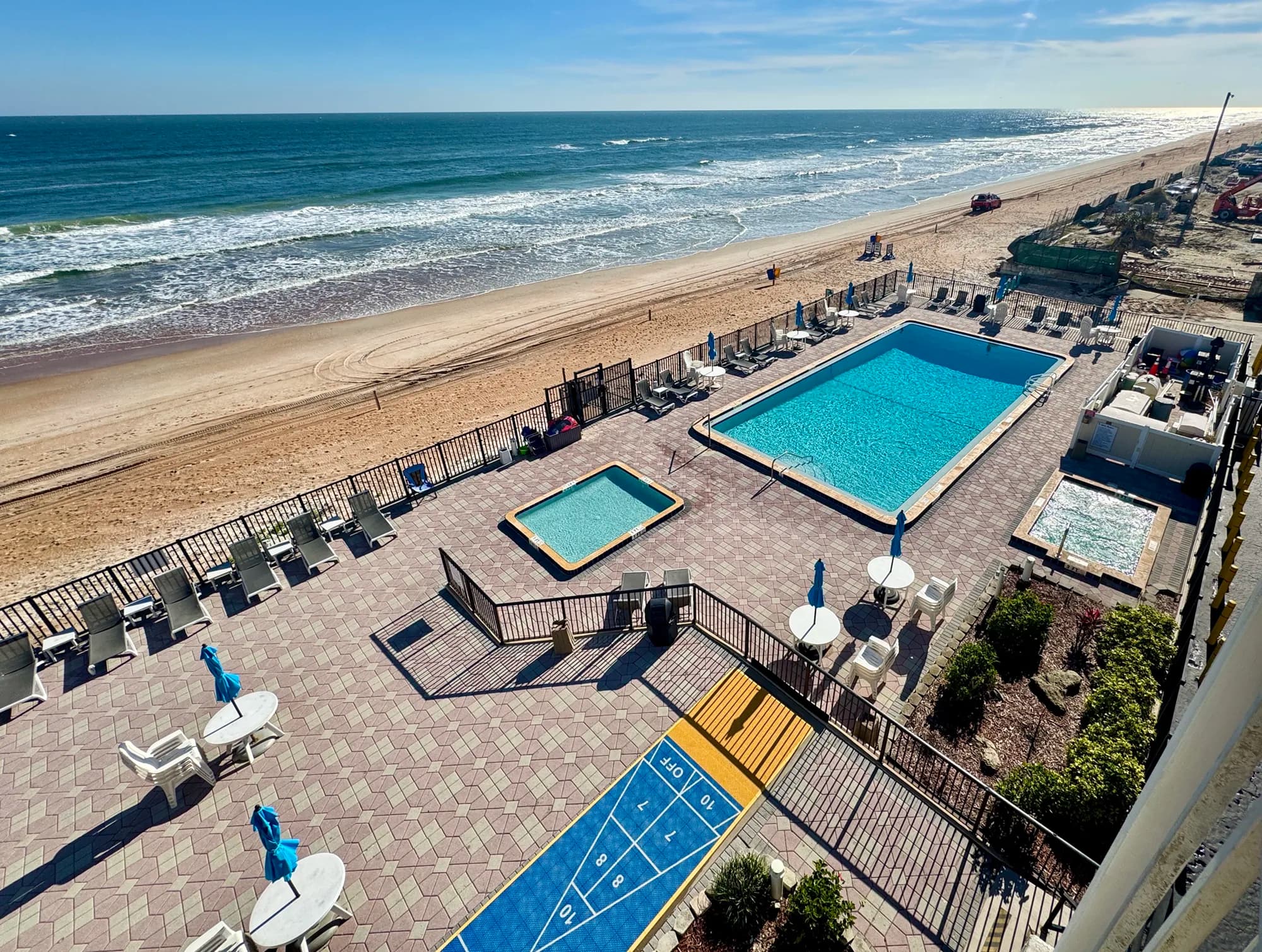 Studio living area with sofa bed, armchair, coffee table, and sliding glass door to balcony.