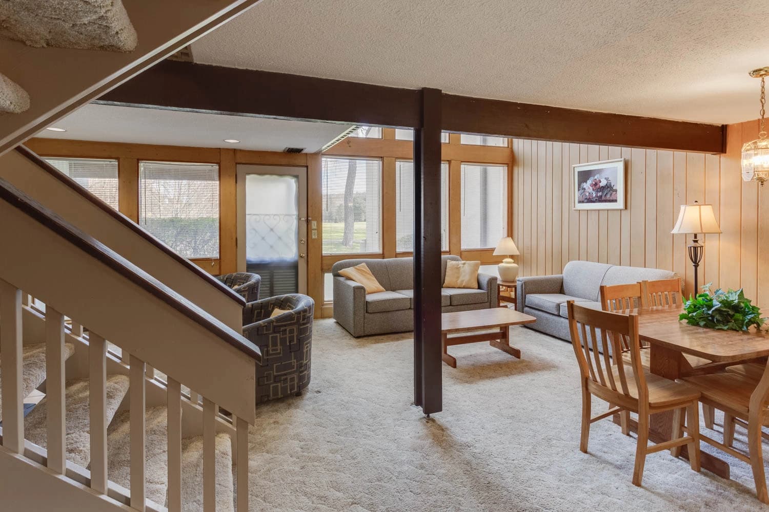 Cozy living area with wooden accents, dining table, and comfortable seating.