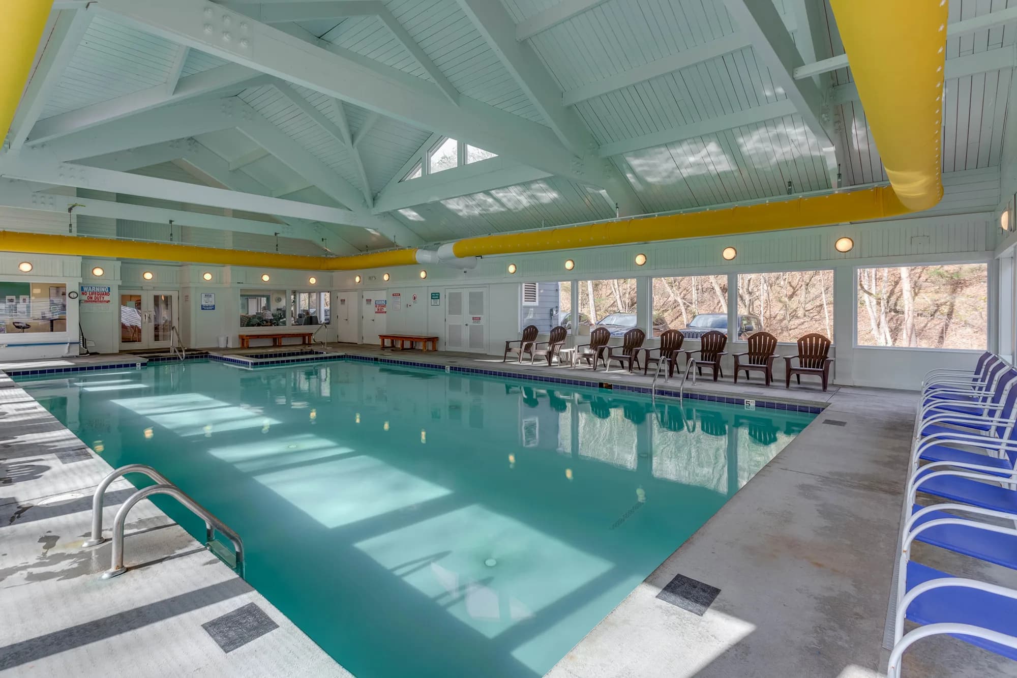 Spacious indoor pool with skylights and seating area.